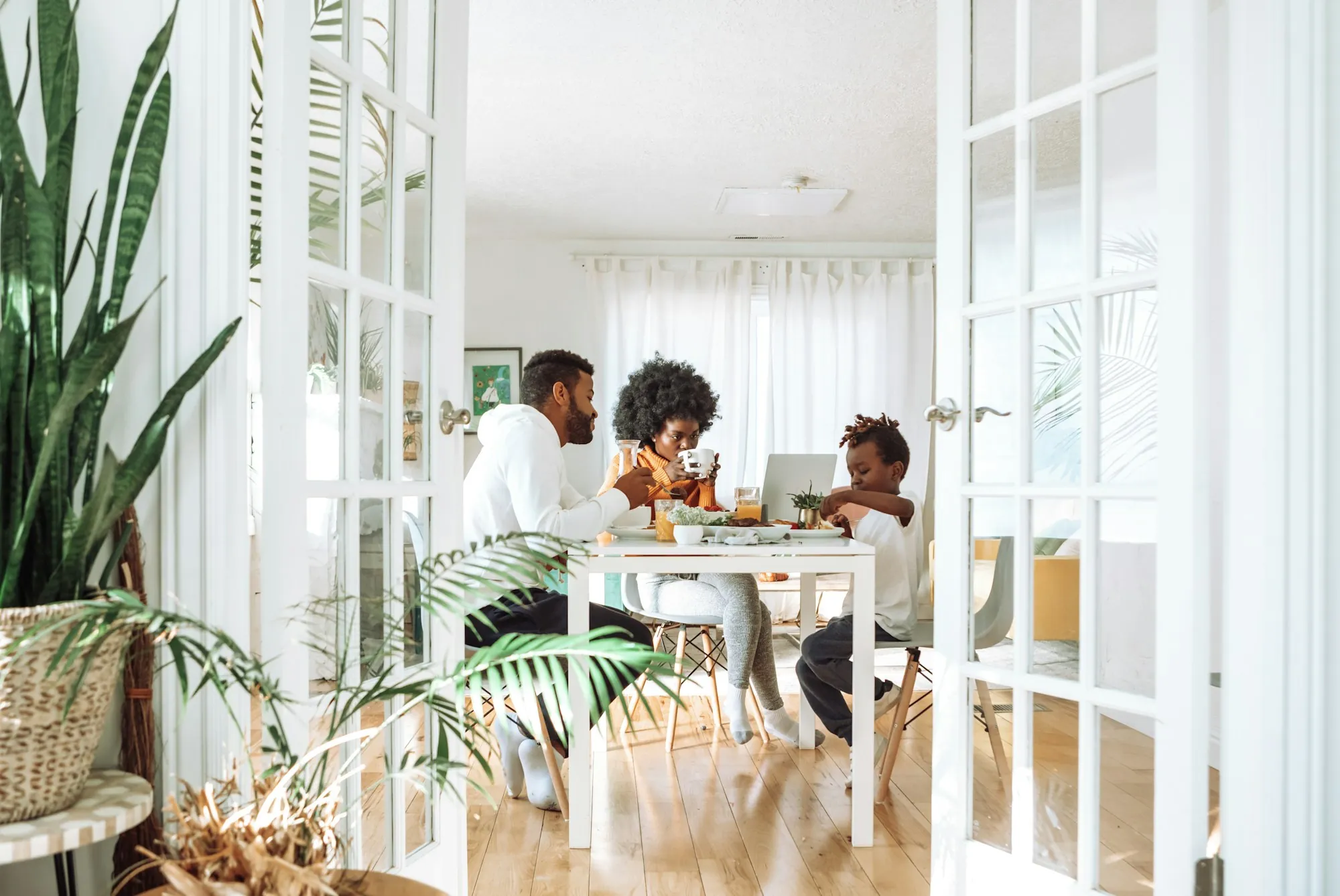 Parents and their young son eating breakfast at a bright dining table, a family weighing child life insurance pros and cons in Northfield