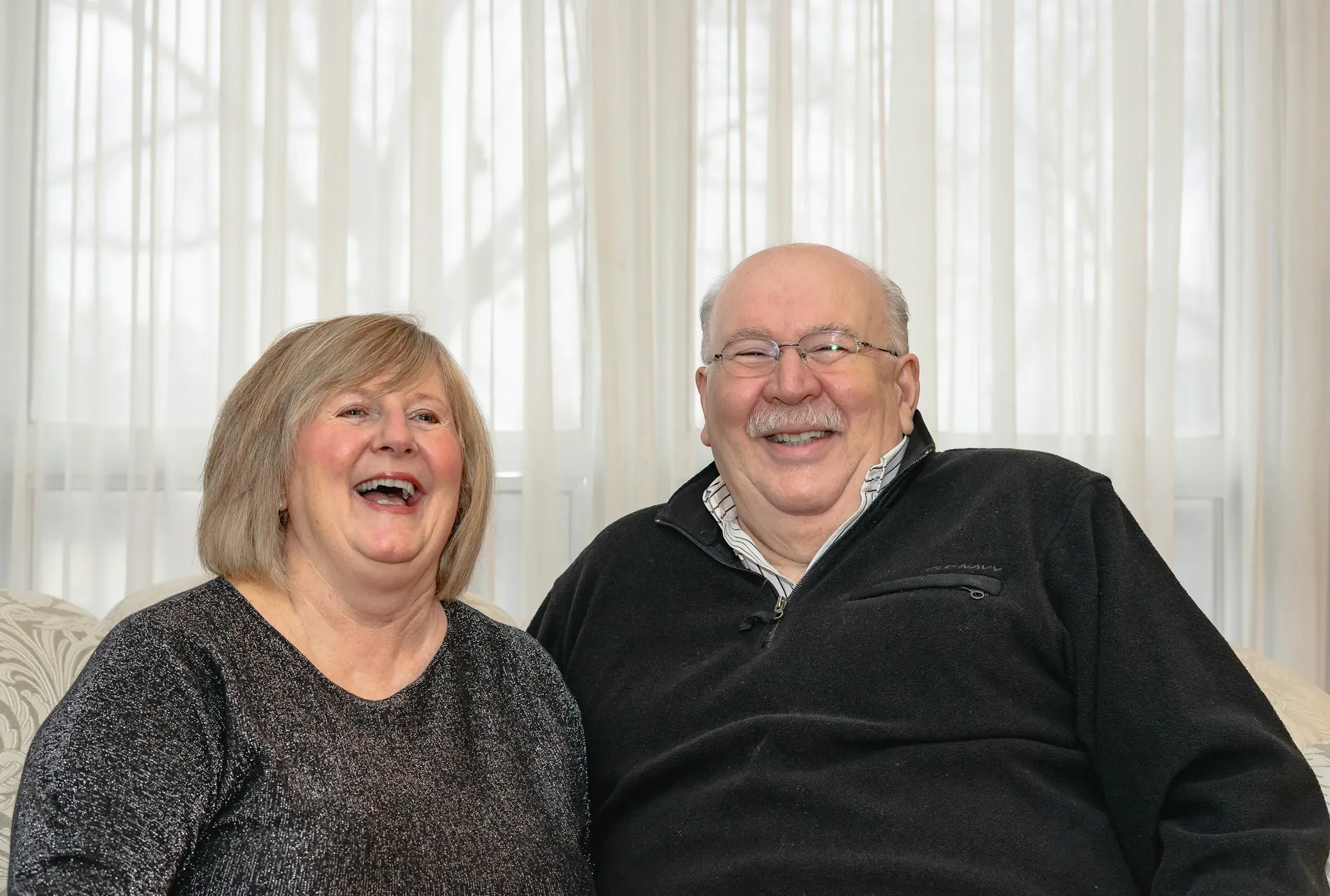 Smiling senior couple sitting together on a sofa