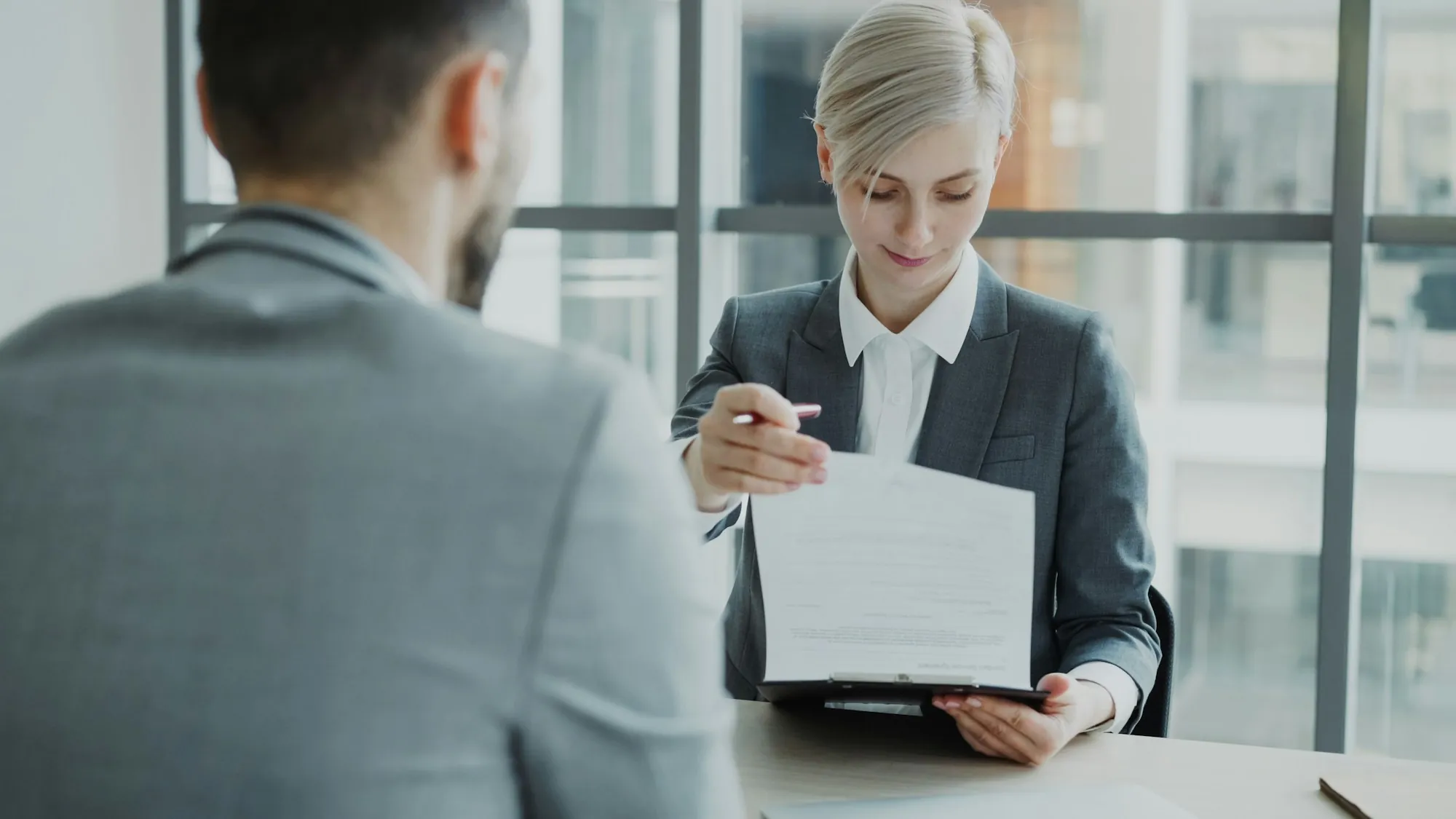 Agent showing a document across a desk