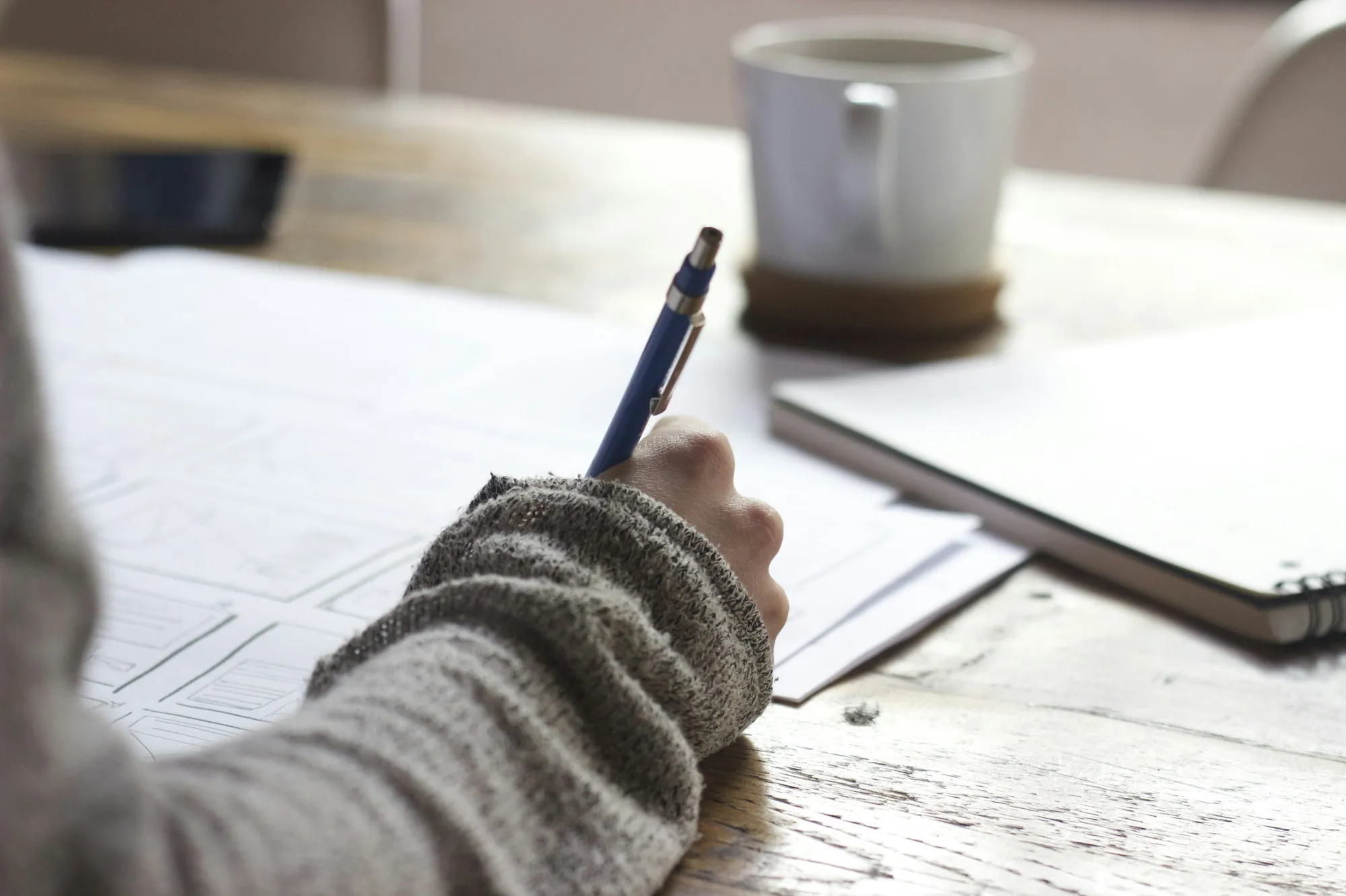 Person writing notes at a table